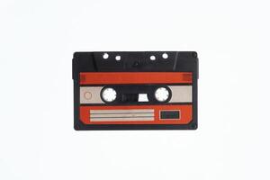 A vintage audio cassette tape with an red and black label, isolated on a white background, evokes nostalgia and retro vibes. photo