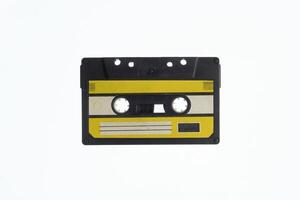 A vintage audio cassette tape with an yellow and black label, isolated on a white background, evokes nostalgia and retro vibes. photo