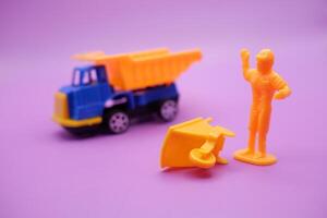 Toy Wheelbarrows and Trucks with Mini Figures on Purple photo