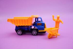 Purple Background with Toy Trucks Wheelbarrows and Mini Figures photo