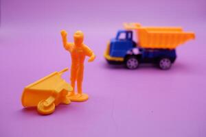 Mini Figures Toy Wheelbarrows and Trucks on a Purple Surface photo