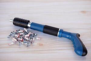 Electric nail gun shooter. Concept, carpenter or mechanic tools. DIY. Fix or repair things. Portable and convenient to make craft or construction easier. photo