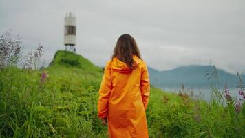 Tourism And Traveling, Brunette Woman In Raincoat Walking To Lighthouse, Rearview, Touristic Trip video
