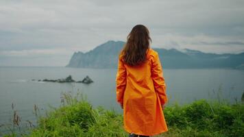 Woman Traveler Walking On Edge Of Cliff And Admiring Picturesque Seascape, Rearview video