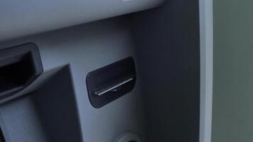close-up of a man's hand taking a paper check from an ATM video