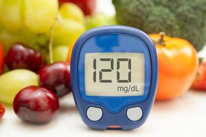 Glucose meter with vegetable and fruit for check sample blood sugar level photo