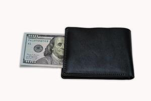 Wallet with hundred dollar bill partially visible on a neutral background photo