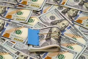 Stacks of cash secured with a binder clip on a bed of dollar bills photo