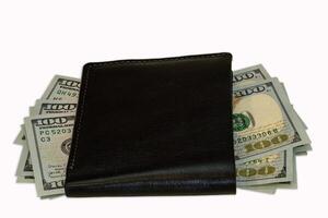 Cash displayed from a black wallet with hundred dollar bills photo