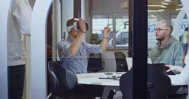 A diverse group of businessmen collaborates and tests a new virtual reality technology, wearing virtual glasses, showcasing innovation and creativity in their futuristic workspace video