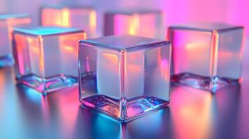 Transparent glass cubes arranged in a row displaying iridescent reflections and holographic effects, illuminated by pink and blue gradient lighting on a white background. surface photo