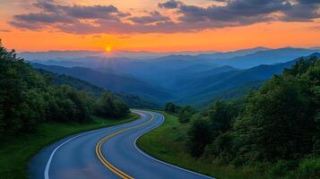 Scenic mountain road curves through rolling hills at sunset, golden sky and dramatic clouds create cinematic landscape with perfect perspective. journeying photo