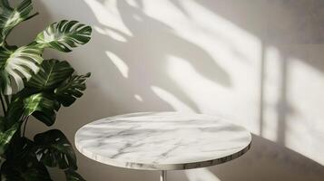 White round marble table features monstera deliciata plant leaves against white wall background. Soft natural lighting casts shadows, creating clean aesthetic in vertical composition. pristine photo