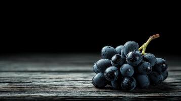Dark Moody Still Life Photography of Fresh Juicy Black Grapes on Rustic Wooden Table photo