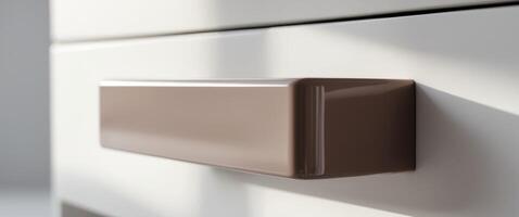 Macro shot of a mocha mousse acrylic desk drawer handle highlighting modern design. photo