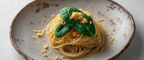 Spaghetti topped with vibrant spinach and a sprinkle of breadcrumbs served on a rustic plate photo