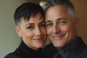 Within softly lit space middle aged transgender couple enjoys tender moment while one partner adjusts other's tie in front of mirror showcasing their love and connection photo