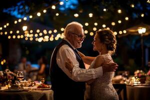 elderly Caucasian couple dances closely in their backyard as evening light casts warm glow. String lights twinkle above creating magical atmosphere for their special moment photo