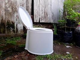 A white toilet sitting outside in a garden photo