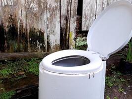 A white toilet sitting outside in a yard photo