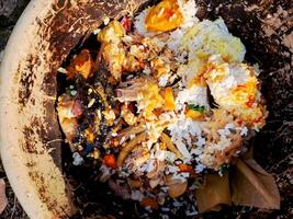 A brown trash can filled with food photo