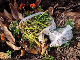 A bag of weeds and flowers sitting on the ground photo