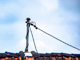 A street light on top of a building with a wire photo