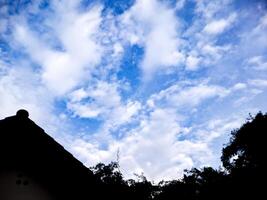 A blue sky with clouds and a roof photo
