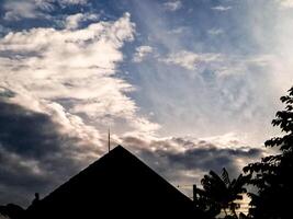 A silhouette of a house with a large sky photo