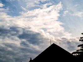 A silhouette of a house with a kite flying in the sky photo