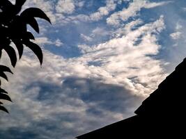 A silhouette of a building and a sky with clouds photo