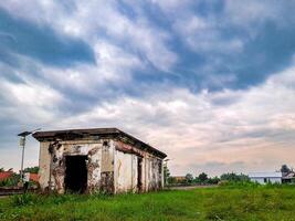 An old building sits in the middle of a field photo