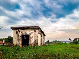 An old abandoned building in the middle of a field photo