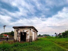 An old building sits in the middle of a grassy field photo