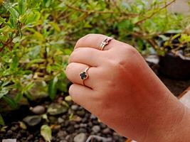 A person holding a ring with a black stone photo