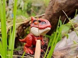 A toy dinosaur with a stick sticking out of it photo