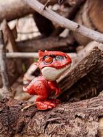 A toy dinosaur is sitting on a log photo