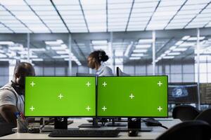 Multi monitor isolated screen computer setup used by engineers working in server hub processing data. Mockup PC displays used by employees to update servers controlling network resources photo