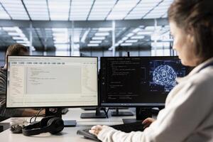Woman using artificial intelligence technology to optimize data center performance. IT professional in server farm using AI tech to streamline operations and accurately forecast potential issues photo