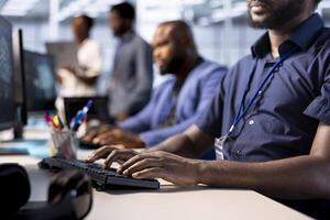 Team of developers in data center using diagnostic tools and system monitoring software to identify root cause of errors. Close up of employees in server farm mending equipment together photo