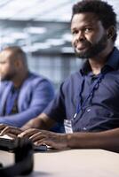 Cybersecurity division staff member monitoring security incidents affecting server hub network. African american developer in data center protecting company critical infrastructure from cyber threats photo