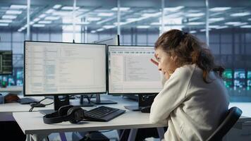 System admin working in computer network security data center, ensuring optimal performance. Worker monitoring energy consumption across operational server racks components, camera B photo