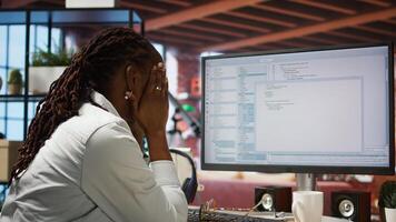 Disappointed engineer in home office looking at UI on computer monitor, failing to properly execute programming code. Displeased IT worker seeing errors while using coding application, camera A photo