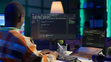 Black software engineer writes complex binary code scripts on computer, cybersecurity. Teleworking IT specialist in home office using programming language to safeguard consumer data. Camera A. photo