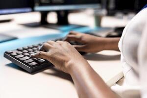 Data center employees typing on PC keyboard, creating technical documentation for software applications. Close up of programmer in server room using computer, maintaining databases photo