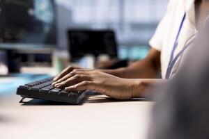 Close up of cybersecurity expert monitoring security incidents affecting server hub network. Programmer in data center typing on keyboard, protecting company critical infrastructure from cyber threats photo