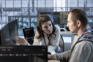 Teamworking colleagues using machine learning to optimize data center operations, improving efficiency of infrastructure. Manager discussing with worker, implementing server virtualization photo