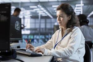 Technician using computer to do maintenance on artificial intelligence neural networks. System administrator using AI system aiding in processing and transmitting information photo