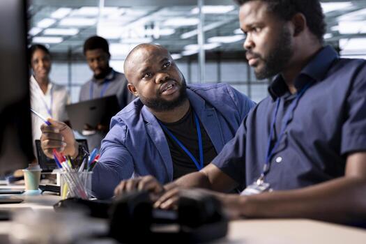 Unhappy manager admonishing technician after failing to properly reconfigure server farm to optimize it for data processing requirements of customers, berating him while pointing to coding mistakes photo