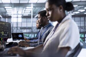 Computer scientists in data center using diagnostic tools and system monitoring software to identify errors. Team of IT specialists in server farm establishment repairing equipment photo
